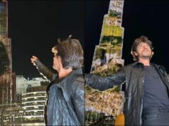 As the Pathaan video plays on Burj Khalifa, Shah Rukh Khan strikes his signature wide-arm gesture.